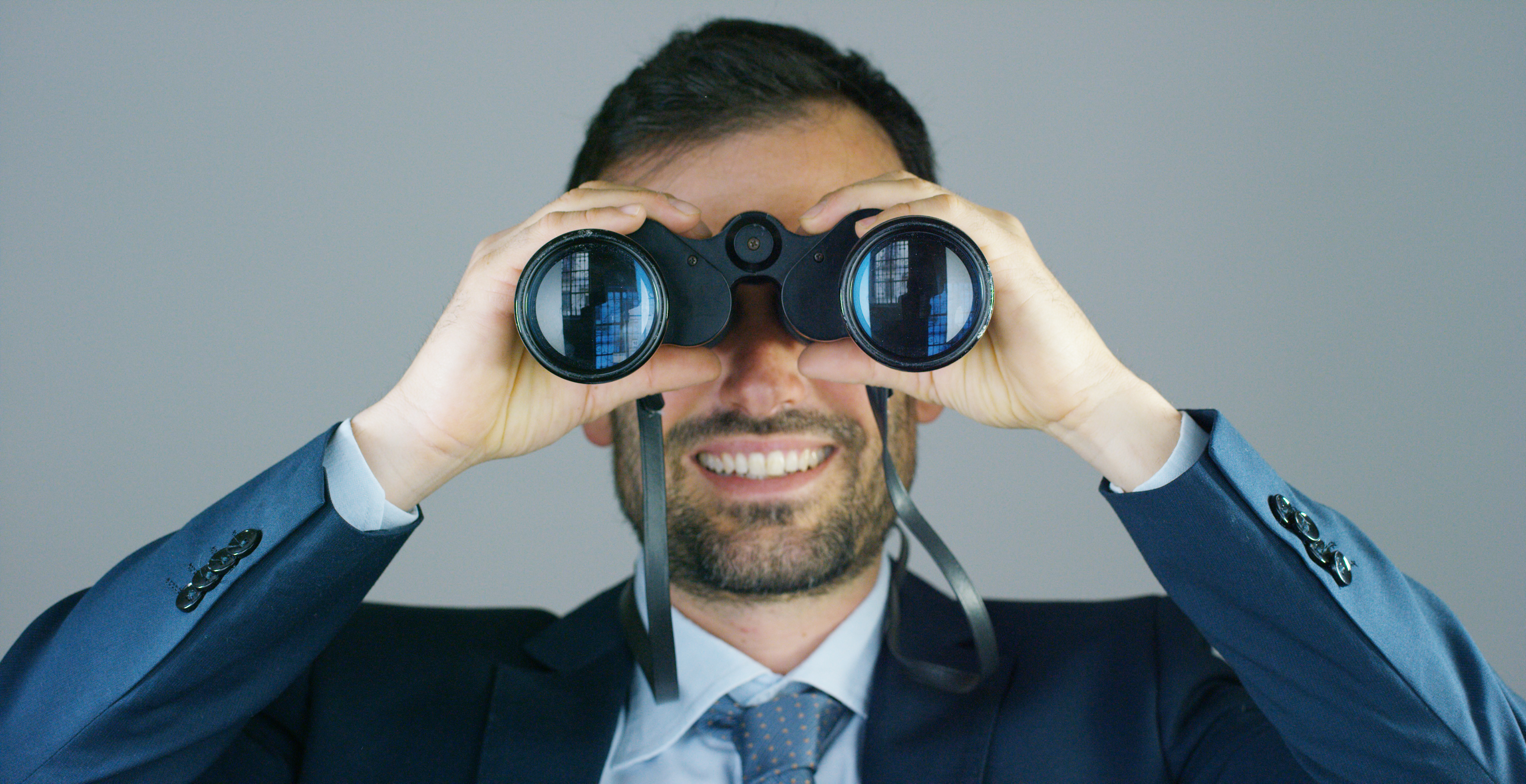 A businessman in a suit and tie, use the binoculars to look away with the concept of looking to the future, forecasting the economic and financial growth and the future A businessman in a suit and tie, use the binoculars to look away with the concept of looking to the future, forecasting the economic and financial growth and the future