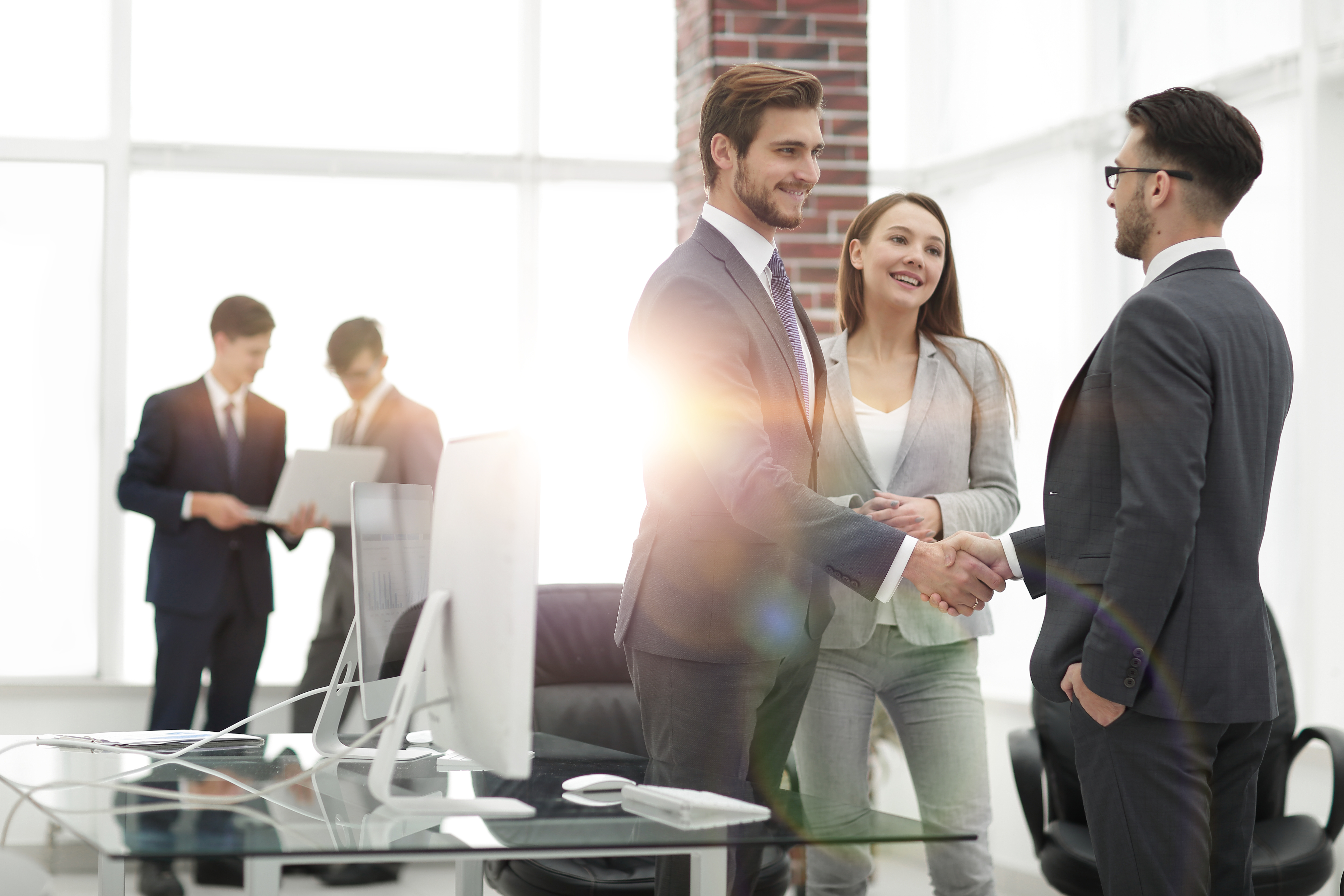 handshake business partners at a meeting Partners concluding deal and shaking hands in the presence of team members